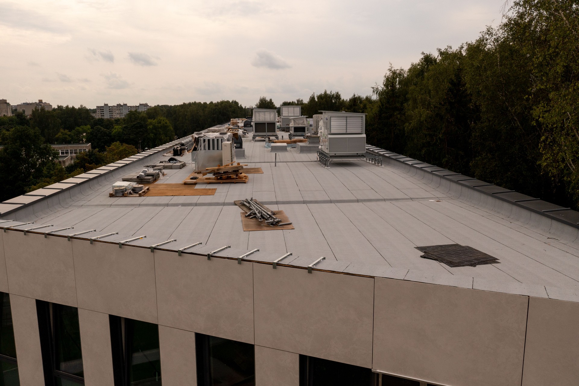 Drone photography of new building rooftop being built with construction equipment